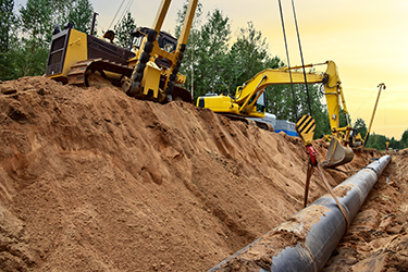 Excavator construction equipment digging a trench for a pipe
